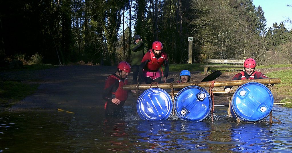 3 people getting on a makeshift raft